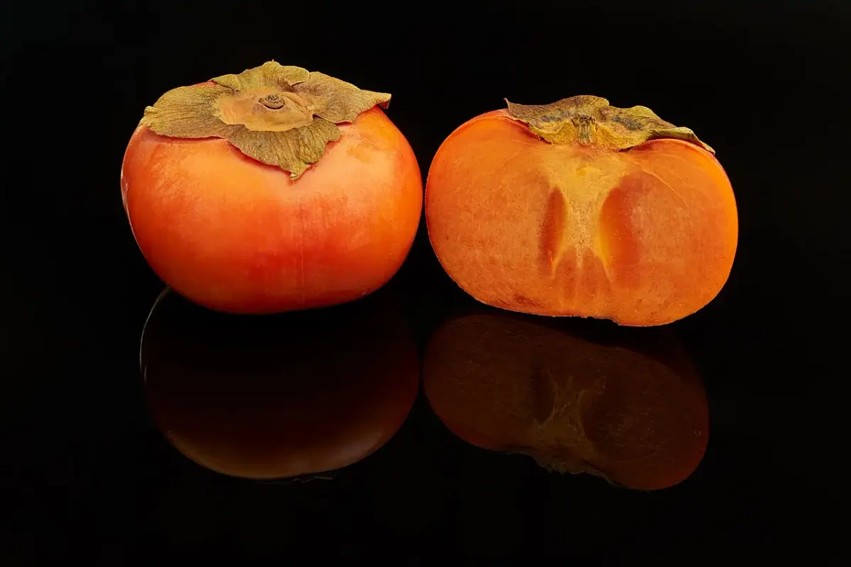 Orange persimmons, including one cut in half
