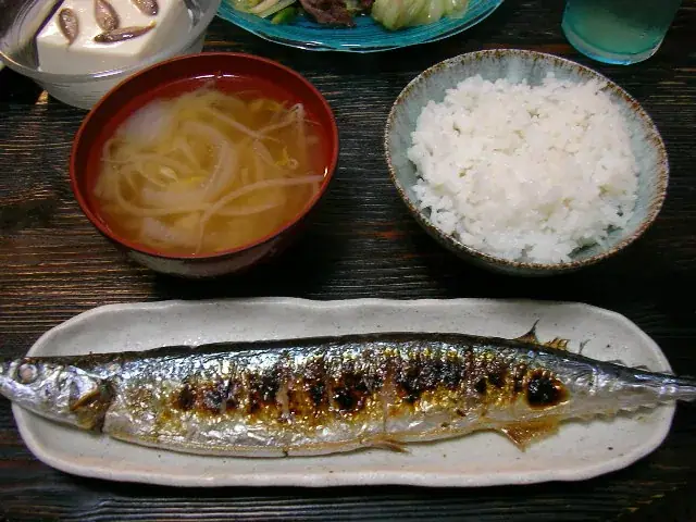 A meal of one grilled sanma fish with rice, miso soup and side dishes